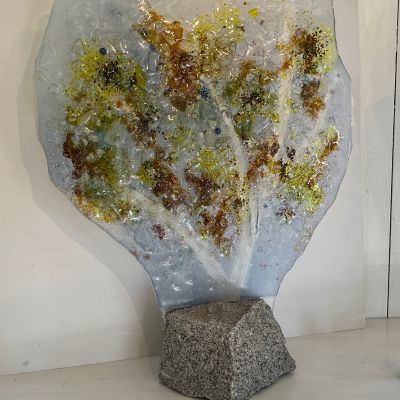 Ulla Hultberg "Höst”  Genom glasets genomskinlighet fångar jag naturens färger, skiftningar och ljus.  Naturens bridge är ett naturligt tema för mig. Motiv som som vatten, landskap och växlighet fascinerar. Teknik Glasfusing eller glas gjutning format i glasugn. Oftast arbetar jag med vanligt fönsterglas, färgpigment och glaskross. Genom att bearbeta underlaget får jag fram strukturer. Teknik:Glasfusing monterad på sten.